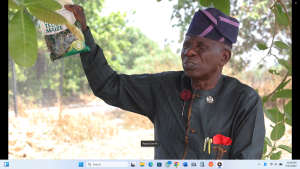 A farmer holding out a pack of TELA Maize seeds